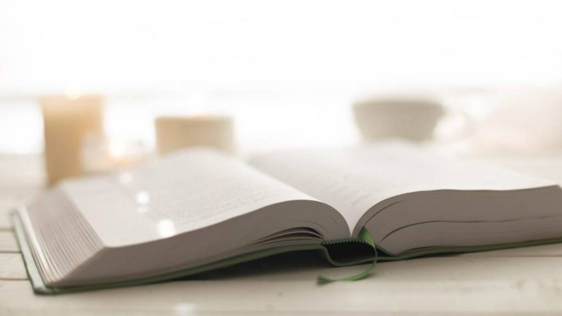 open bible on a picnic table with a bright sunrise in the background